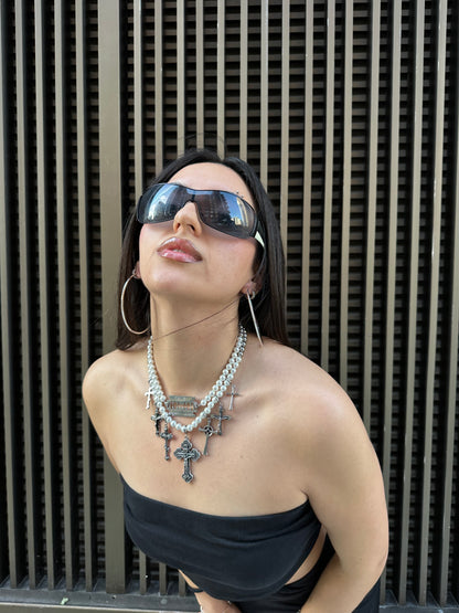 Woman wearing Mercy necklace with multiple crosses, adorned with pearls and stainless steel beads, in an elegant and stylish pose.